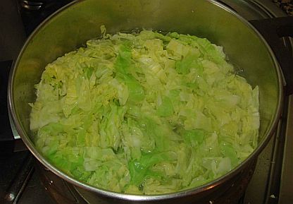 Boiling shredded cabbage.